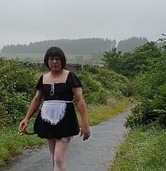 Transvestitenmädchen in einer öffentlichen Gasse im Regen